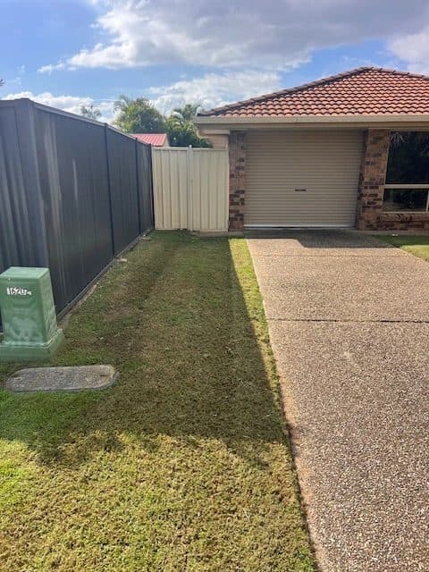 Mown strip of lawn beside a driveway and garage